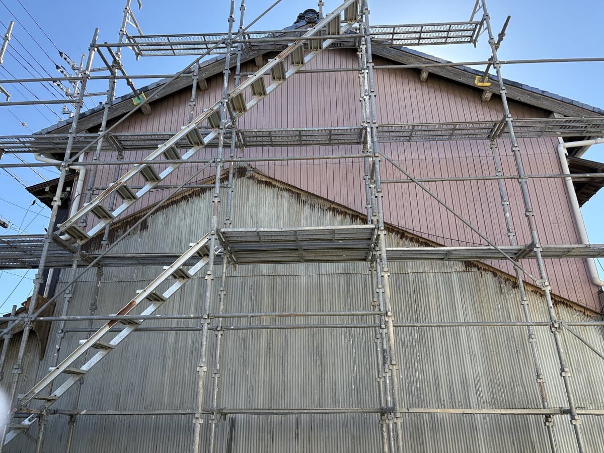 成型角波の施工前。既存の外壁と建物を囲む足場